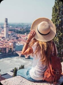 Traveler in straw hat overlooking riverside town