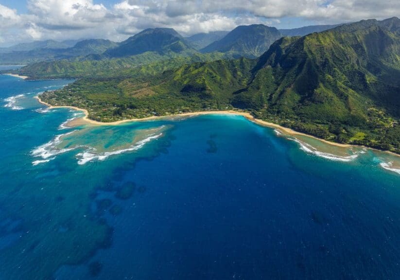 Aerial view of Kauai coastline and lush green mountains in Hawaii